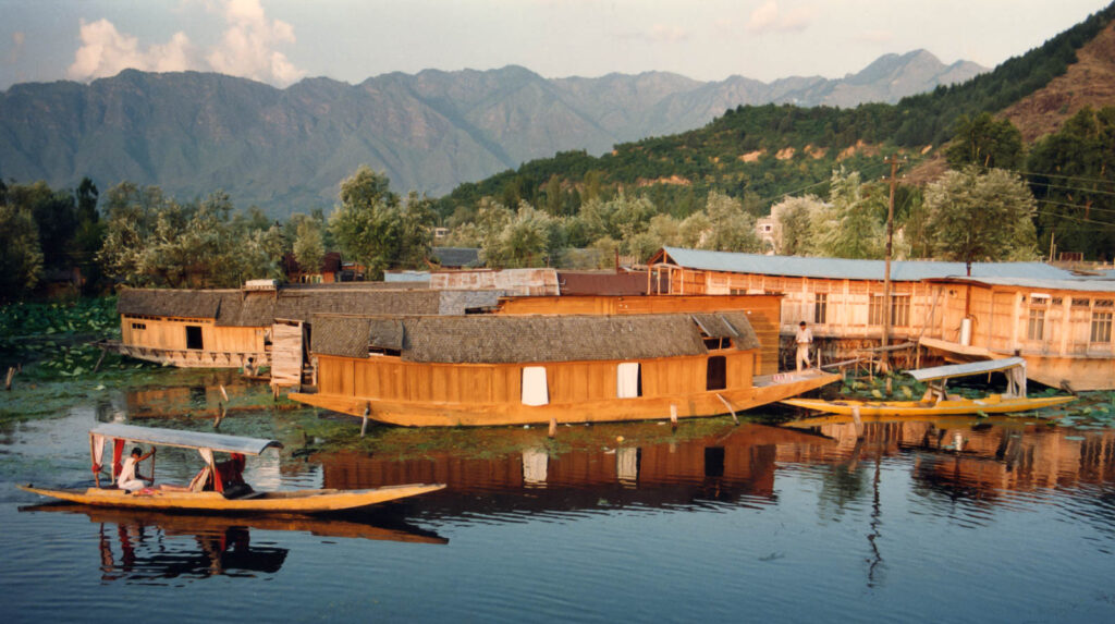 Vista sobre el lago Dal en Srinagar, principado de Kashmir en la India. Se aprecian una shikara (especie de canoa) y casas bote en la que habitan los residentes o pernoctan turistas si están acondicionadas como hotel